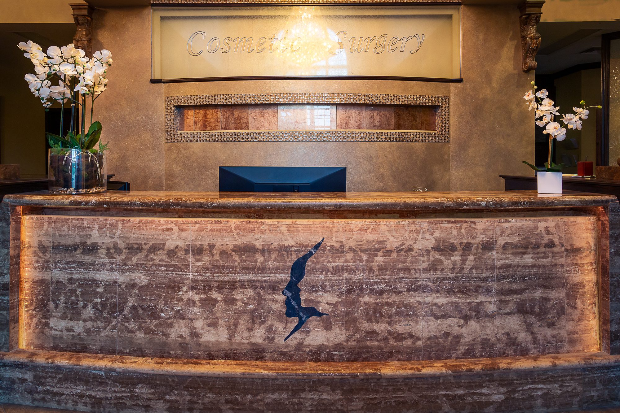 The reception desk at the Tulsa Surgical Arts villa, in stone with orchids on either side